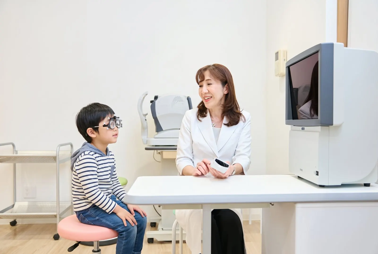検眼枠をかけたお子さまと院長
