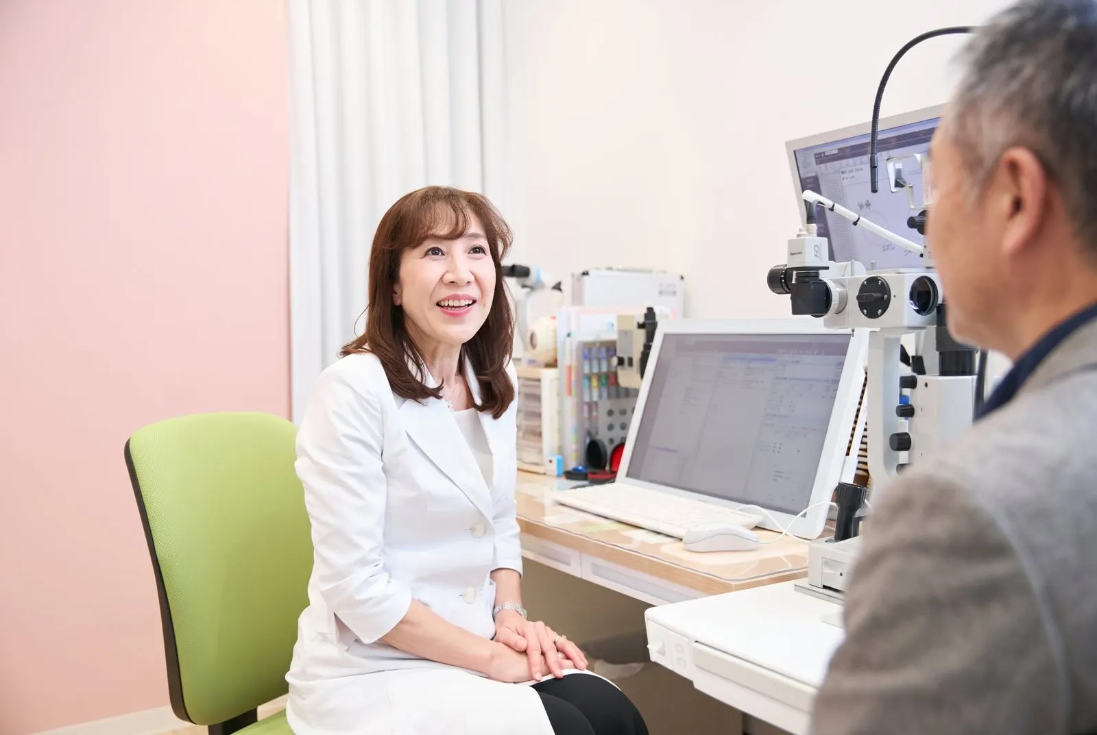 診察室で院長が患者さんに目の状態を説明している様子